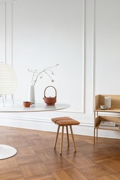 two chairs and a table with vases on it in a white living room setting