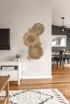 a living room with white walls and wooden flooring next to a tv mounted on the wall