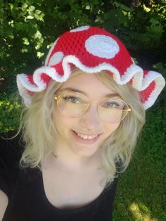 a woman wearing glasses and a crocheted mushroom hat