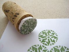 a wine cork with a green and white snowflake stamp sitting on top of it