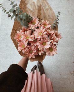 a person holding a bouquet of pink flowers