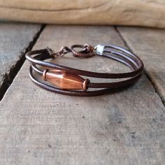 a brown leather bracelet with copper colored beads