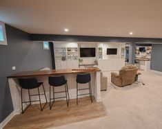 a living room filled with furniture and a bar