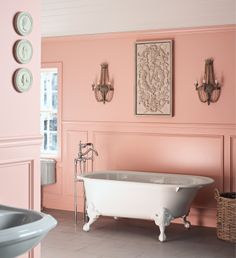 a bathroom with pink walls and a white bathtub in the middle of the room