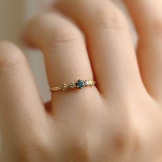 a woman's hand with a ring on it that has two stones in the middle