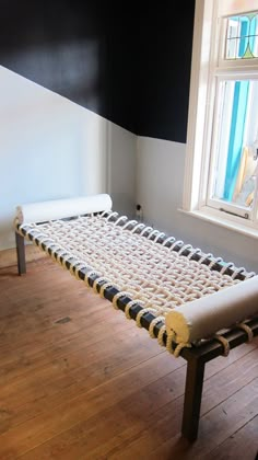 a bed frame sitting on top of a hard wood floor next to a white wall