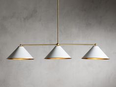 three white lamps hanging from a brass chandelier