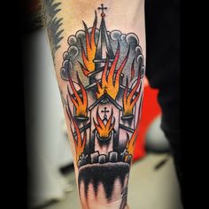 a man with a tattoo on his leg that has flames coming out of the building