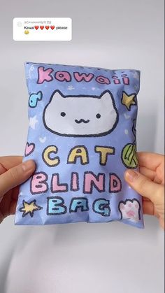 someone is holding up a pillow that has a cat on it and the words kawaii are written in different languages