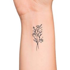 a small flower tattoo on the wrist