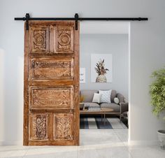 an open wooden door in the middle of a living room with a couch and potted plant