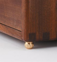 a close up of a wooden bed frame with brass knobs on the bottom and sides