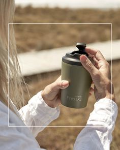 a woman holding a coffee cup in front of her face