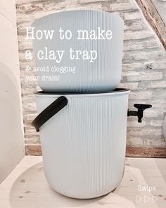 a white toilet sitting on top of a wooden floor next to a brick wall with words above it