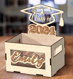 a wooden box with a graduation cap and name on it