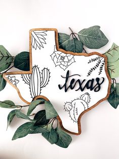 a decorated texas state shaped cookie with the word texas written in black and white on it