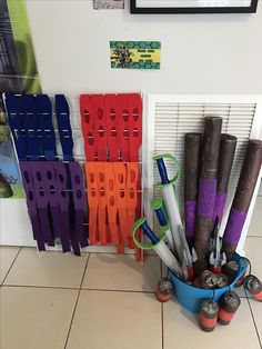 a bucket filled with lots of colorful umbrellas next to a wall mounted art piece