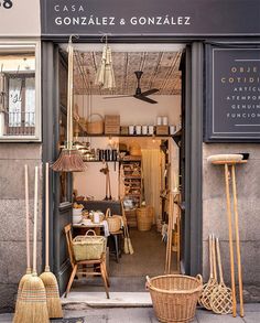 a store front with baskets and brooms outside