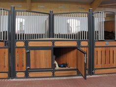 the inside of a horse stable with wooden stalls