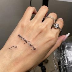 a woman's hand with a small tattoo on it