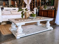 a white coffee table sitting on top of a wooden floor next to a bed in a room