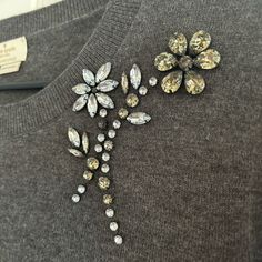 a sweater with flowers and stones on it