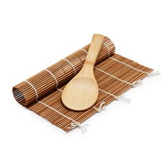 two wooden spoons sitting on top of a bamboo mat