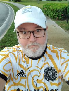 a man with a white beard wearing a yellow and white shirt