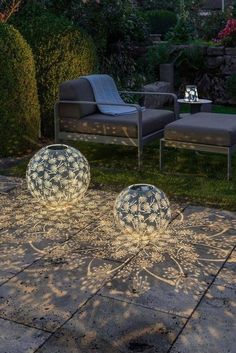 two blue and white balls sitting on top of a stone floor next to a lawn