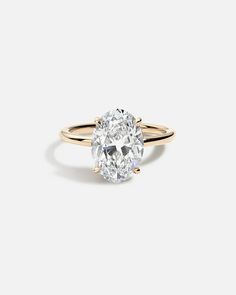 an oval cut diamond ring in yellow gold