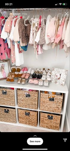 a baby's closet with baskets and clothes hanging on the wall next to it