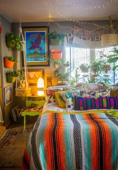 a bed room with a neatly made bed and lots of plants