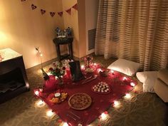 a table topped with pizza and other food on top of a red cloth covered floor