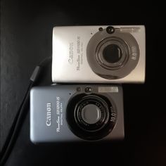 two digital cameras sitting on top of each other