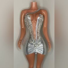 a plastic mannequin with silver dress on display