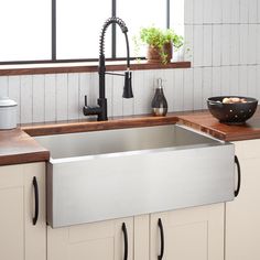 a kitchen sink that has some vegetables in it and is next to the counter top