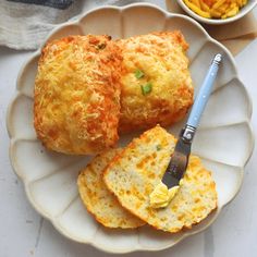 two pieces of bread on a white plate with a bowl of macaroni and cheese in the background