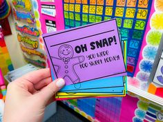 a person holding up a purple card with the words oh snap on it in front of colorful background