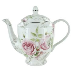 a white tea pot with pink roses on the outside and green leaves on the inside