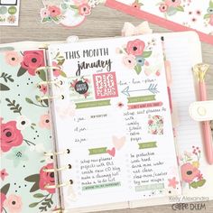 an open planner with flowers on it next to a pen and paper clippings