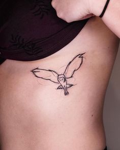 a woman's stomach with a bird tattoo on her side, and the bottom part of her lower back