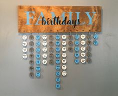 a wooden sign hanging from the side of a wall that says, happy birthday with lots of blue and white buttons