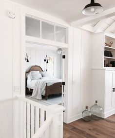 a bedroom with white walls and wooden floors