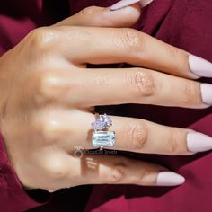 a woman's hand with white nails and a ring