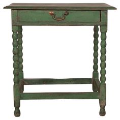 an old green wooden table with two drawers on one side and a drawer on the other