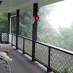 a porch with rocking chairs on it and trees in the background