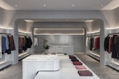 the inside of a clothing store with clothes on racks