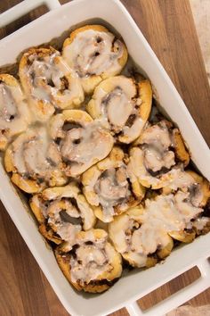 a casserole dish filled with mushrooms on top of a wooden table