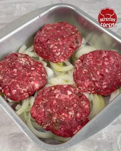 three hamburger patties in a metal pan with onions