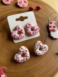 pink and white donuts with sprinkles sitting on top of a wooden table